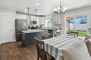 Dining space featuring dark wood-style floors, recessed lighting, and a chandelier