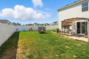 Fenced backyard featuring a patio area, a pergola, and a residential view