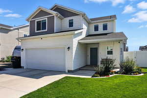 View of front of property featuring board and batten siding, concrete driveway, an attached garage, and a shingled roof