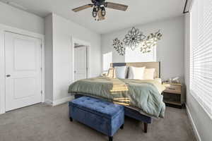 Carpeted bedroom featuring baseboards and ceiling fan