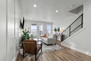 Living room with stairway, wood finished floors, recessed lighting, and a textured ceiling