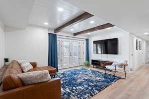 Living room featuring french doors, wood finished floors, recessed lighting, and beam ceiling