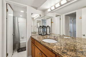 Full bath with vanity, shower / bath combo, and tile patterned floors