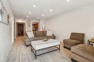 Living area with recessed lighting and light wood-type flooring
