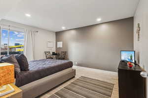 Bedroom with an office area, light wood-style floors, and recessed lighting