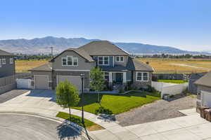 Craftsman house featuring concrete driveway, stucco siding, a mountain view, and a garage