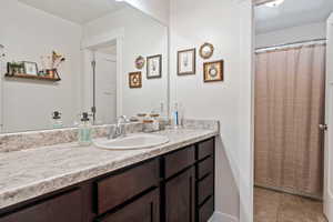Full bath with vanity, tile patterned flooring, and a shower with shower curtain