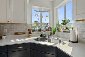 Kitchen with decorative backsplash and white cabinetry