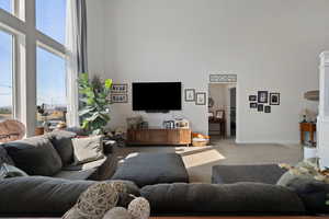 Living room featuring a towering ceiling and light carpet