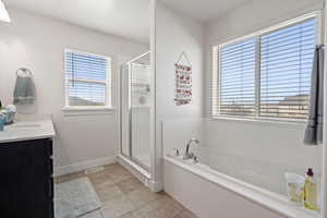Full bathroom featuring a garden tub, vanity, a shower stall, and tile patterned floors