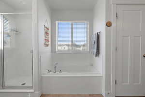 Bathroom with a garden tub, a stall shower, and tile patterned flooring