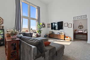 Living area with carpet and a towering ceiling