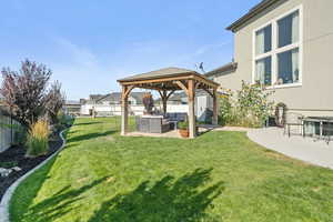Fenced backyard featuring outdoor lounge area, a patio, and a gazebo