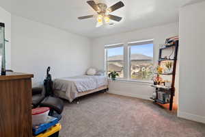 Bedroom with carpet, a mountain view, and a ceiling fan