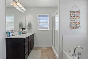 Bathroom with double vanity, a garden tub, an enclosed shower, and tile patterned flooring