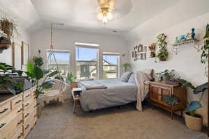 Bedroom with lofted ceiling, light carpet, and a ceiling fan