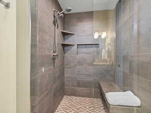 Bathroom with a tile shower and a textured ceiling