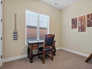 Office space featuring light colored carpet and baseboards