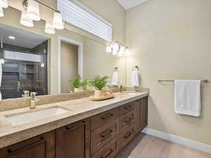 Full bath with tile patterned floors, double vanity, and a shower stall