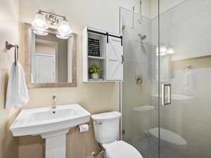 Full bathroom with toilet and a shower stall