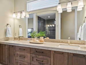 Full bath featuring double vanity and a shower stall