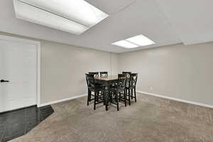 Tiled dining room featuring carpet floors and a paneled ceiling