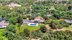 Aerial view of property and surrounding area featuring a pool area and property parcel outlined