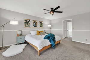 Carpeted bedroom featuring baseboards and ceiling fan