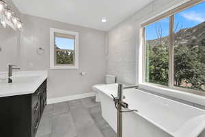 Bathroom featuring a freestanding tub, vanity, and recessed lighting