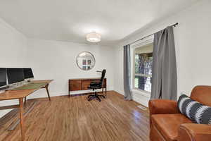 Office space with light wood-style flooring, crown molding, and a textured ceiling