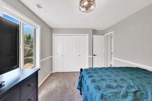 Carpeted bedroom featuring baseboards and a closet