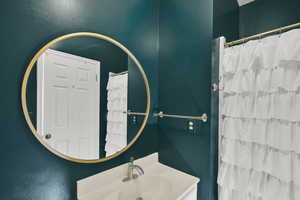 Full bathroom featuring vanity and a shower with shower curtain
