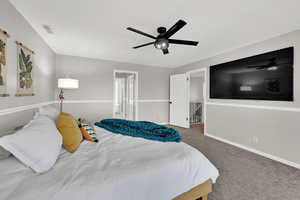 Bedroom featuring carpet, a ceiling fan, connected bathroom, and a walk in closet