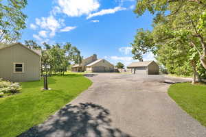 View of front facade featuring a front yard, a detached garage, and a residential view