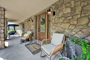Property entrance featuring stone siding and a porch
