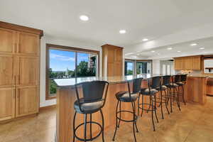 Kitchen featuring recessed lighting, tasteful backsplash, a large island, a kitchen breakfast bar, and light tile patterned flooring