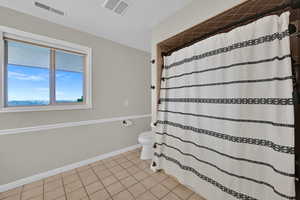 Bathroom featuring tile patterned floors and curtained shower