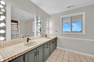 Bathroom featuring tile patterned flooring and double vanity