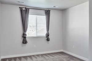Unfurnished room with baseboards and carpet flooring