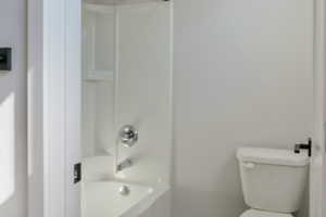 Bathroom featuring toilet and bathtub / shower combination