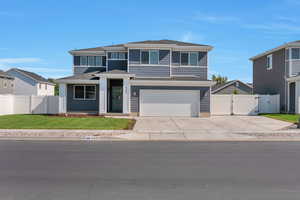 View of front facade featuring a gate, driveway, an attached garage, and roof with shingles