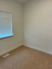 Spare room featuring baseboards and light colored carpet