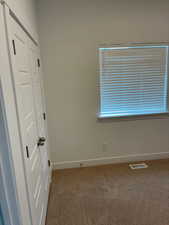 Unfurnished bedroom featuring a closet and light carpet