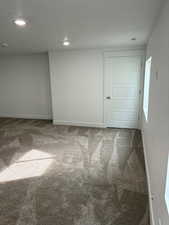Carpeted empty room featuring recessed lighting