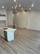 Kitchen featuring white cabinetry, light wood finished floors, an island with sink, dishwasher, and recessed lighting