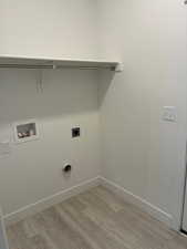 Laundry area with light wood-type flooring, hookup for a washing machine, and electric dryer hookup