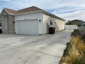 View of home's exterior featuring driveway, stone siding, and an attached garage