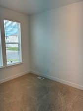Carpeted empty room featuring baseboards