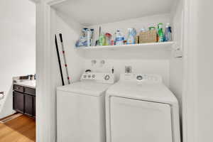 Washroom with independent washer and dryer and light wood finished floors