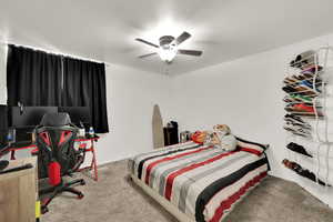 Bedroom featuring carpet floors, an office area, and ceiling fan